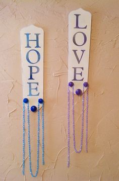 two wooden signs that say hope and hope with beads hanging from the side of them