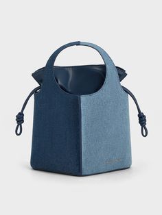 This product is made with at least 20% sustainable materials by weight. CHARLES & KEITH uses recycled, degradable, organic, and water-based materials in our eco-conscious collection.A chic denim bag will instantly elevate your wardrobe and look -- and this Arlys bucket is it. Right from the get-go, you will be immediately drawn to the unique design elements of this bag -- from the contrasting light and dark denim finish to the sleek diamond-shaped construction which come together to create a str Sustainable Bag, Mini Bucket Bags, Mini Bucket, Collection Ideas, Elegant Bags, Denim Chic, Size Chart For Kids, Charles Keith, Drawstring Pouch