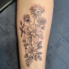 a black and white flower tattoo on the left leg, with flowers growing out of it