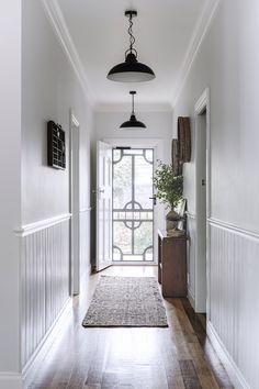 Timber panelling and timber floorboards make this classic country-style white hallway shine. Country Hallway, Hampton Style House, Country Style Magazine, White Hallway, Home Hallway, Entrance Way, 1970s Home, Wood Heater, Timber Panelling