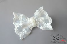 a white lace bow with pearls on it