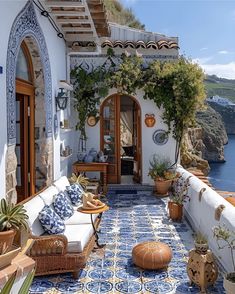 an outdoor living area with blue and white tiles on the floor, potted plants and pots