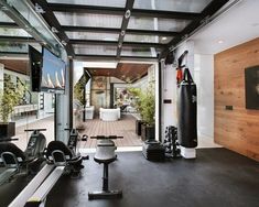 a home gym with exercise equipment in the center and large mirrors on the wall behind it