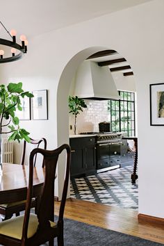 a dining room table with chairs and a potted plant in the middle of it