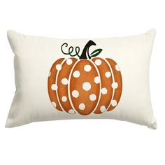 a white pillow with an orange pumpkin on the front and polka dots on the back