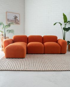 an orange couch sitting on top of a rug