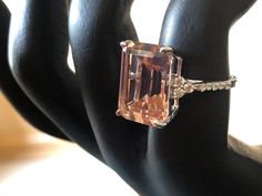 an orange diamond ring sitting on top of a black mannequin