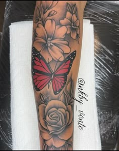 a woman's arm with flowers and a butterfly on it