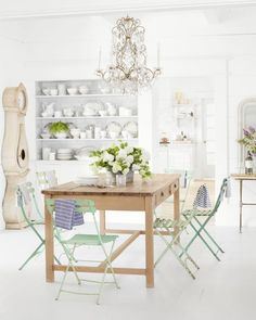 a dining room table with chairs and a chandelier hanging from it's ceiling