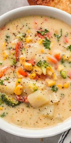 a white bowl filled with soup next to some bread