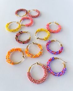 Hoop earrings adorned with vibrant seed beads create a playful and eye-catching accessory.  The wire intricately weaves through an array of colors, adding a lively touch to the classic hoop design and making these earrings a stylish and versatile statement piece. Details: ✨100% handmade with meticulous care ✨Quality 18k real gold plated hoop earrings  ✨Premium-quality glass seed beads ✨Tarnish resistant brass beading wire ✨Wired on 25mm hoop earrings  ✨Weights approximately 6g/pair  Shipping:  F Trendy Colorful Beaded Hoop Earrings For Gifts, Multicolor Small Hoop Jewelry With Spacer Beads, Trendy Hoop Earrings With Tiny Beads For Gift, Pink Small Hoop Jewelry For Festival, Multicolor Hoop Jewelry With Spacer Beads, Wire Wrapped Multicolor Hoop Earrings, Multicolor Wire Wrapped Hoop Earrings, Multicolor Wire Wrapped Hoop Earrings With Round Beads, Multicolor Wire Wrapped Beaded Earrings