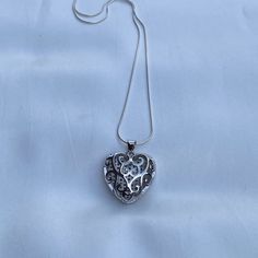 Both sides of this heart pendant are beautiful and will add versatility to your accessories. It comes on a sterling silver snake chain with a delightful silky feel. Wear it by itself or stack it with other necklaces. Necklace- Length: 16 or 20 inches- Width: 0.7mm- Clasp: spring clasp- Metal: 925 sterling silver- Finish: high polishPendant- Size: 23x22x9mm, Hole: 3mm- Material: Brass and Cubic Zirconia- Metal Color: Platinum Orders ship within two days Monday to Saturday Elegant Heart Necklace With Silver Chain For Gift, White Snake Chain Jewelry Gift, White Snake Chain Necklace For Gift, Elegant Sterling Silver Heart Pendant Locket Necklace, Silver Open Heart Necklaces With Heart Beads, Elegant Silver Heart Pendant Charm Necklaces, Silver Heart Necklace With Round Pendant For Her, Silver Open Heart Necklace With Heart Beads, Elegant Heart Pendant Necklace With Box Chain