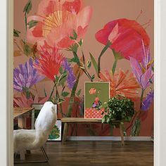 an open door leading to a room with flowers painted on the wall and a white chair