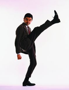 a man in a suit and tie doing a kick