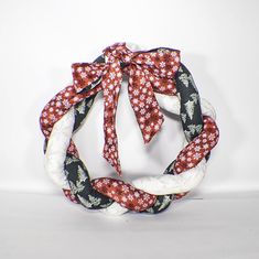 a red, white and black flowered scarf tied in a knot on a white background