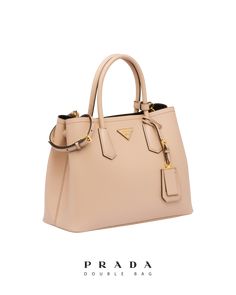 Find PRADA Saffiano Leather Double Bag on Editorialist. The Prada Saffiano Leather Double Bag is crafted from Saffiano leather and features leather handles, a detachable and adjustable leather shoulder strap, a leather name tag with metal details, metal hardware, and a metal lettering logo on a leather triangle at the front. The bag features snap closure on the sides and a nappa leather lining with flap pocket. It also has small feet on the bottom. Designer Calf Leather Satchel For Everyday Luxury, High-end Bags In Textured Saffiano Leather, High-end Calf Leather Satchel For Everyday Luxury, High-end Epsom Leather Shoulder Bag For Everyday Luxury, High-end Saffiano Leather Shoulder Bag With Gold-tone Hardware, Elegant Saffiano Leather Bag With Palladium Hardware, Luxury Textured Epsom Leather Bag, Chic Saffiano Leather Shoulder Bag With Leather Handles, Luxury Saffiano Leather Satchel With Leather Handles