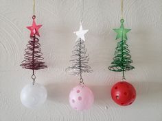 three ornaments are hanging on the wall in different colors and sizes, including one with a christmas tree ornament