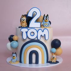 a two tiered birthday cake with cartoon characters on top