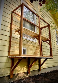 a bird cage sitting on the side of a house