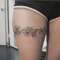 a close up of a person's thigh with flowers on the lower part of her leg