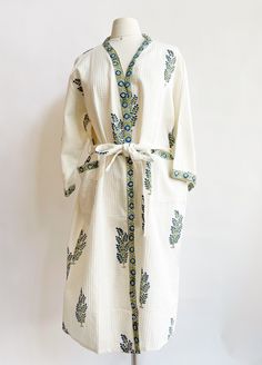 Snuggle into luxury with this unique Waffle Green & Blue Flower Bathrobe. Crafted with block printing and veggie dye, this one-of-a-kind waffle fabric cotton robe is sure to be a cozy favorite. Plus, it's locally made in India, so you know it's the real deal! Wrap yourself in the ultimate comfort. Two pockets on each side to keep your night time goodies. One size fits all Length 46" Width 27" Machine wash cold and hang to dry. Night Robe Cotton, Green Bath Robes, Bath Robe Fabric, Cloud Patterned Robe, Blue Waffle Robe, Long Quilted Robe, Luxury Wrap, Waffle Fabric, Block Printing