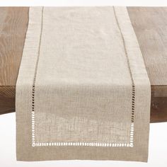 the table runner is made from linen and has white stitching on it's edges