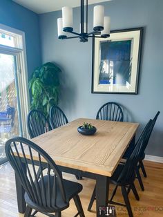 a dining room table with chairs and a bowl of fruit on it