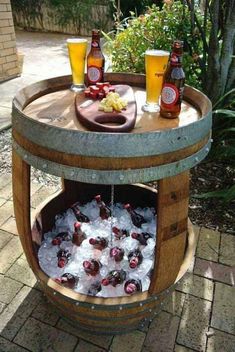 an old barrel turned into a bar with ice and beer