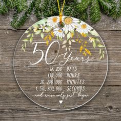 a personalized glass ornament for someone's 50th birthday with daisies and leaves