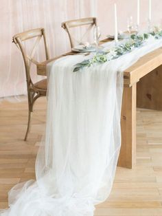 the table is set with candles, flowers and greenery as well as an organ - lined runner