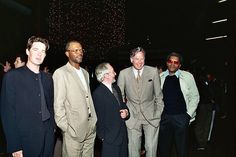 a group of men standing next to each other in front of a ceiling full of confetti