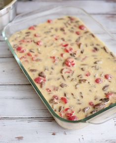 a casserole dish with tomatoes and mushrooms in it on a white wooden table