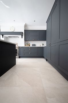 a kitchen with gray cabinets and white counter tops