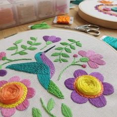 a close up of a embroidery on a table with scissors and other crafting supplies