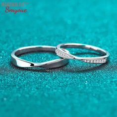 two wedding rings sitting on top of a blue surface with sparkles around them and the words marriage simplice written in white gold