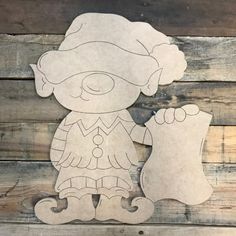 a cutout of a teddy bear wearing a hat and holding a bone on a wooden background