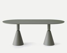 an oval table with two small grey cones on the top and one large gray cone on the bottom