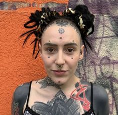 a woman with tattoos and piercings on her face