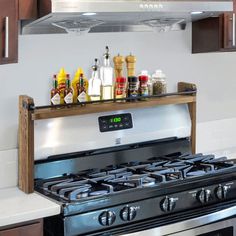 an oven with spices and bottles on the shelf above it