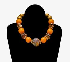 an orange and gold beaded necklace on a black mannequin with a white background