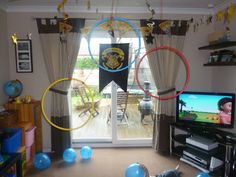 a living room filled with furniture and balloons hanging from the ceiling next to a flat screen tv