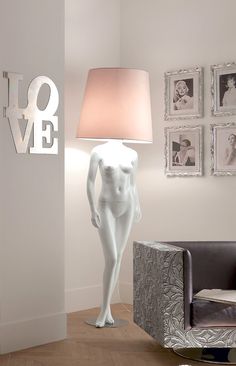 a white mannequin standing next to a lamp in a living room