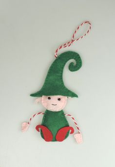 Handmade Felt Elf, hanging decoration, handmade with bead eyes and a stitched detail mouth. Curly hat and boots Each Elf is unique and has a character of its own, I create each one so they are slightly different. padded design. length approx 14cm, not including the bakers twine hanging loop. Each felt character, brooch or bookmark is handmade in sleepy Shropshire, each item is unique there are never two the same, I enjoy incorporating buttons into every design. Felt Elf, Advent Tree, Elf Crafts, Diy Felt Christmas Ornaments, Diy Tree Decor, Elf Decorations, Elf Magic, Sewing Crochet, Twig Tree