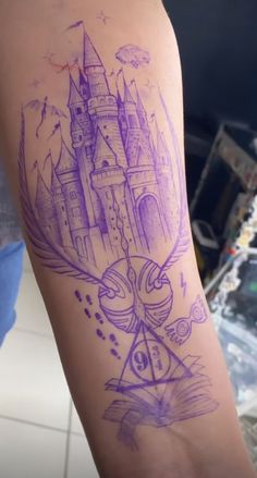 a tattoo on the arm of a woman with a hogwarts castle in purple ink