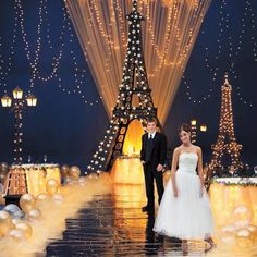 a bride and groom standing in front of the eiffel tower at their wedding