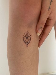 a woman's leg with a tattoo on it and a heart in the middle