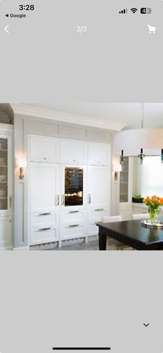 an image of a kitchen with white cabinets and black counter tops on the phone screen