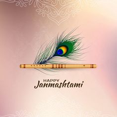 a peacock feather resting on a bamboo flute with the words happy janmastami written below it