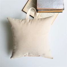 a white pillow sitting next to an open book