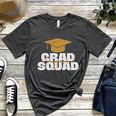 Graduation Squad Shirt, Graduate Shirt, Squad Shirt, Grad Squad Shirt, Proud Family Of The Graduate, Congrats Shirt, Graduation Shirt 2023! Everyone needs the perfect t-shirt to complement an everyday, laid-back look. The ideal top for so many occasions, this lightweight cotton tee will keep you comfy and looking smart. * 100% combed and ring-spun cotton (Heather colors contain polyester) * Fabric weight: 4.2 oz/yd² (142 g/m²) * Pre-shrunk fabric * Side-seamed construction * Shoulder-to-shoulder Grad Squad Shirt Ideas, Short Sleeve Shirt With Text Print For Graduation, Casual Graduation Shirt With Text Print, Casual Shirt With Text Print For Graduation, Casual Cotton Tops For Graduation, Black School Spirit Tops For Graduation, Black School Spirit Top For Graduation, Graduation School Spirit Short Sleeve Tops, Graduation Text Print Crew Neck Top